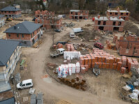 Budowa osiedla, widok z góry, budynki na różnym etapie wznoszenia oraz skład z materiałami